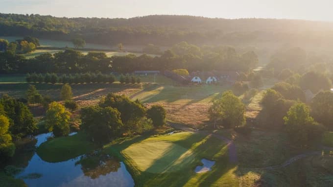 Morning light across the lake and wooded countryside at Mad Swans